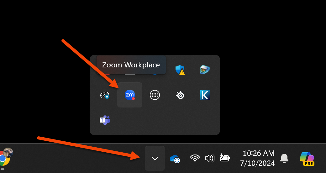 The image shows the bottom-right corner of a Windows desktop screen, specifically the system tray area. There are two red arrows highlighting different parts of the image: The first arrow points to an icon within the expanded system tray, labeled "Zoom Workplace." This indicates that the Zoom Workplace application is running and has a notification. The second arrow points to the button used to expand or collapse the system tray icons. This button, when clicked, shows or hides additional icons from the system tray.